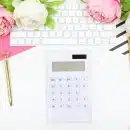 white calculator beside pink rose