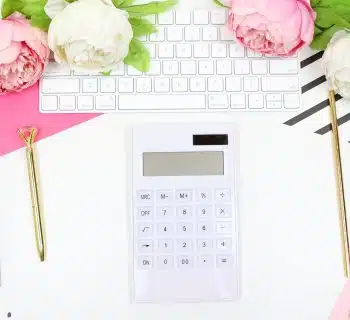 white calculator beside pink rose