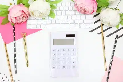 white calculator beside pink rose