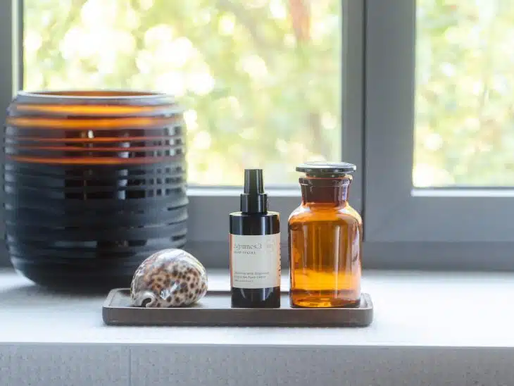 a window with a bowl of food and a bottle of liquid